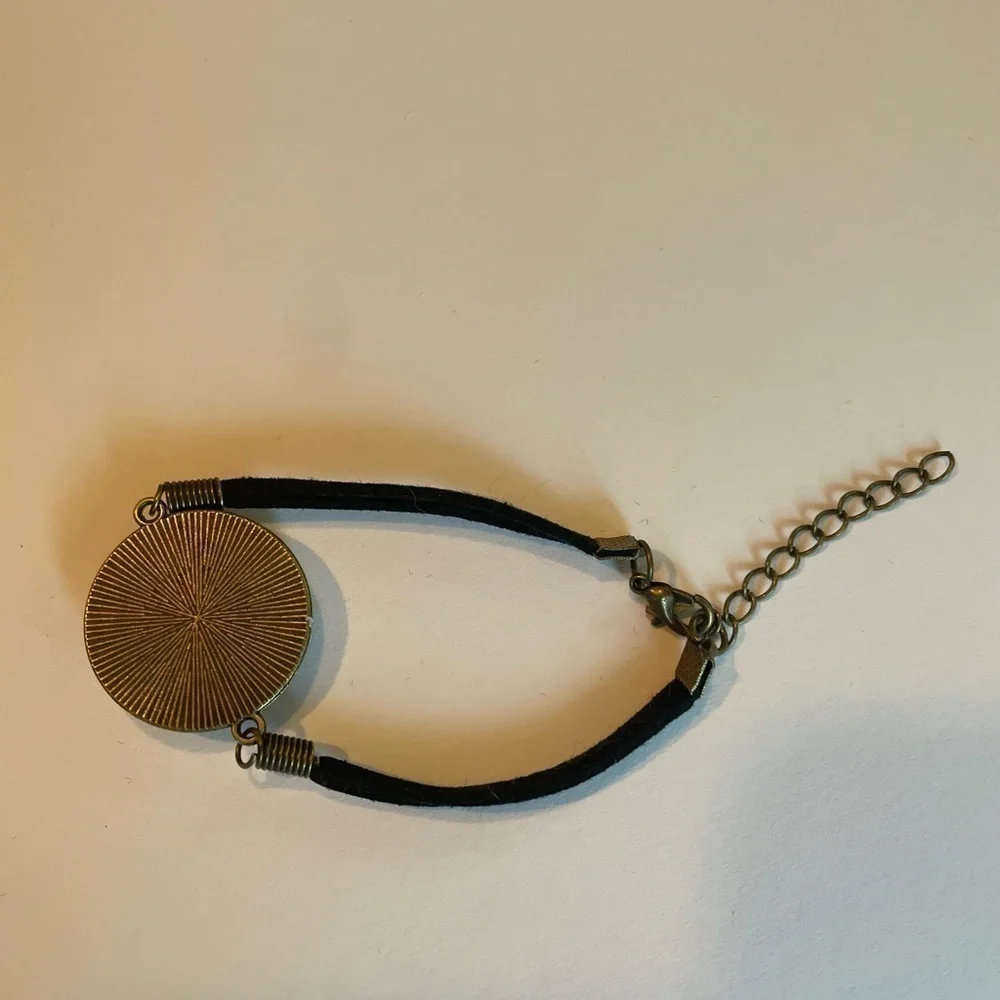 Hand painted acrylic design on glass bracelet.  Attached to metal.  Adjustable